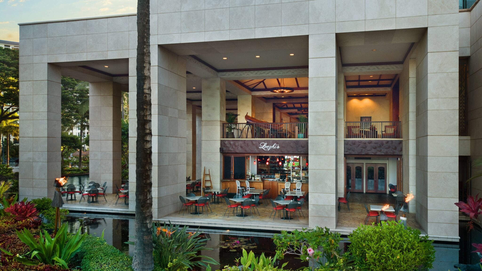 Elegant open-air lobby dining with tropical gardens and reflecting pools