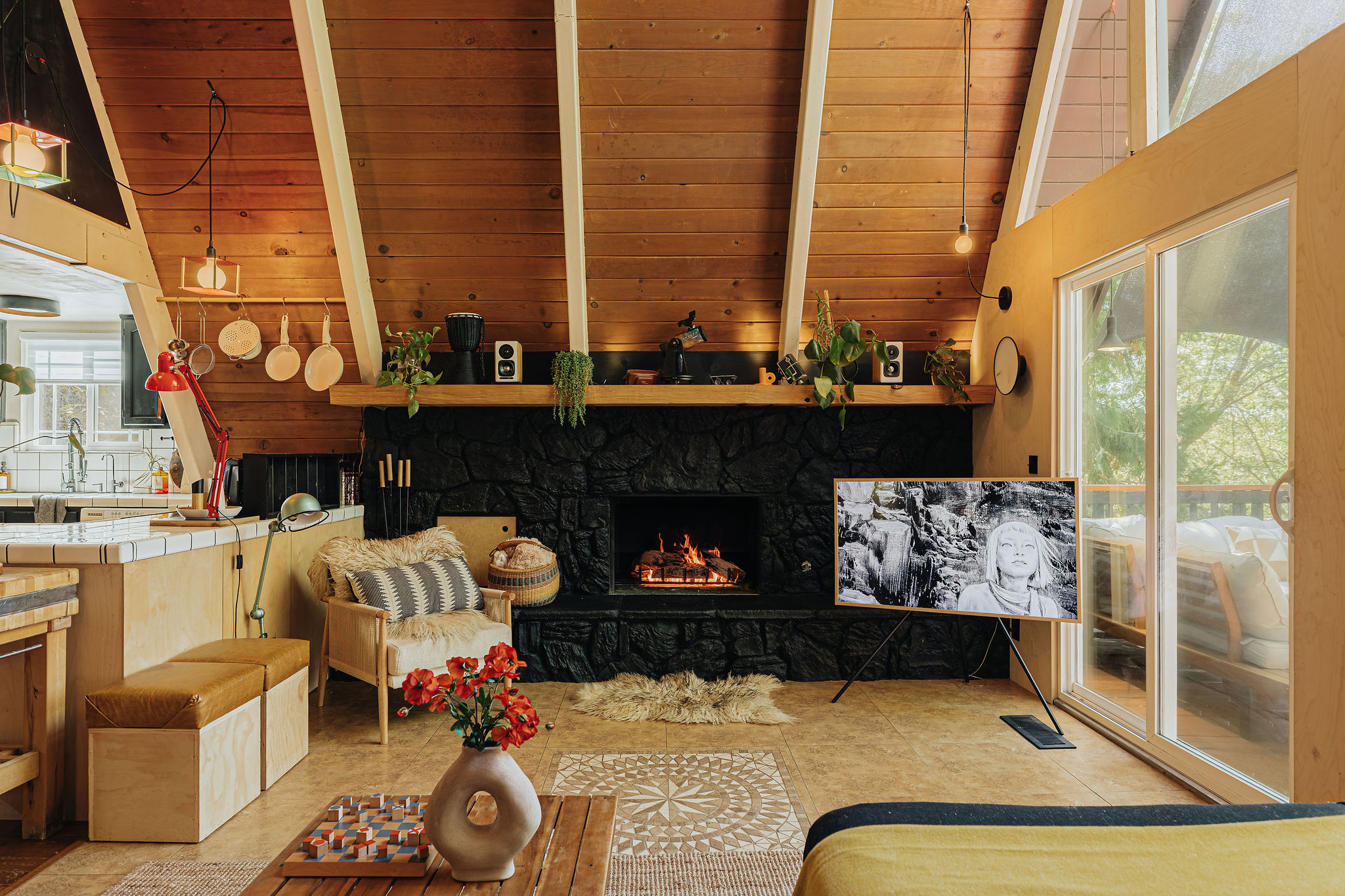 Cozy A-frame living room with stone fireplace and sunlit cabin charm