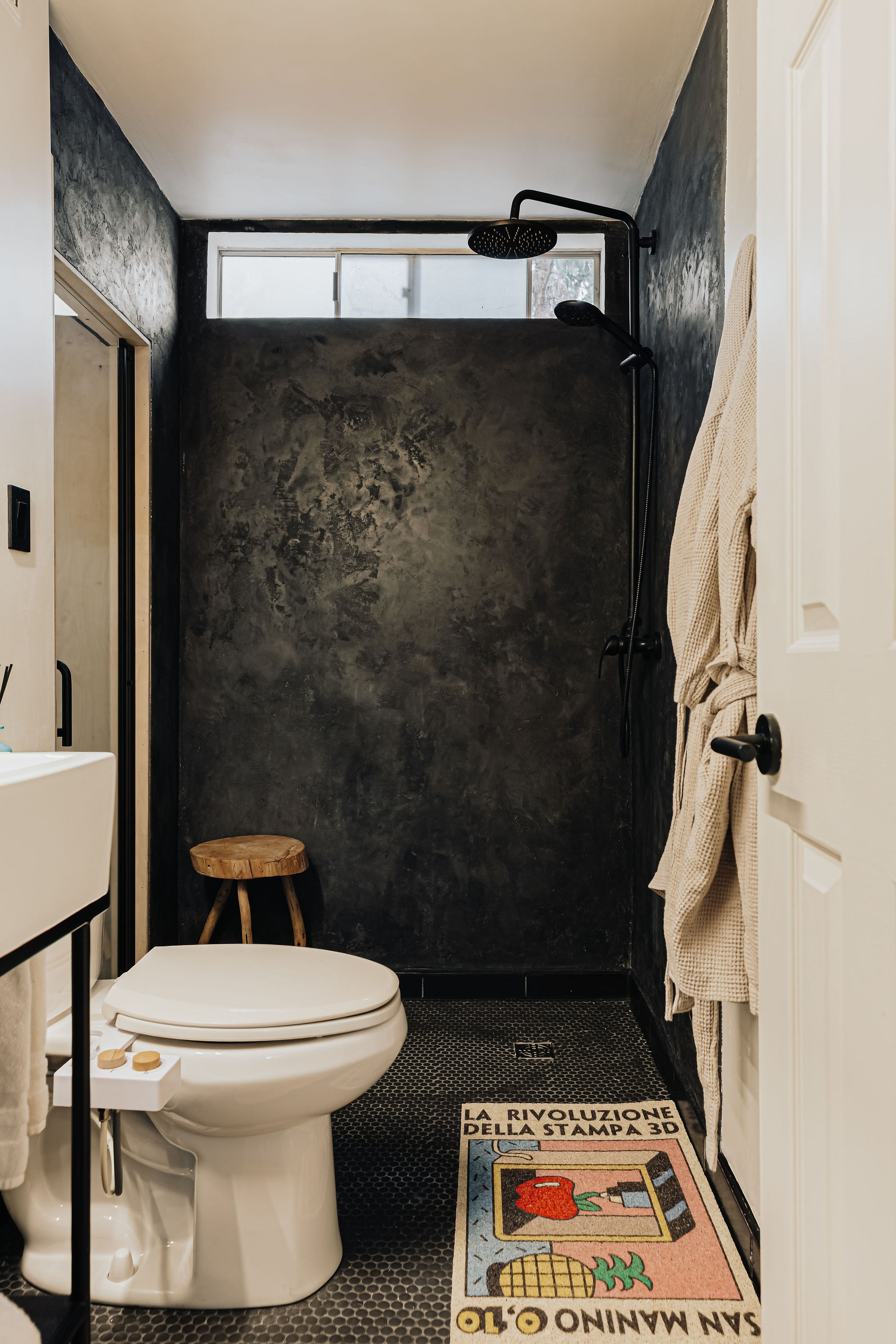 Moody modern bathroom with walk-in shower and striking black finishes