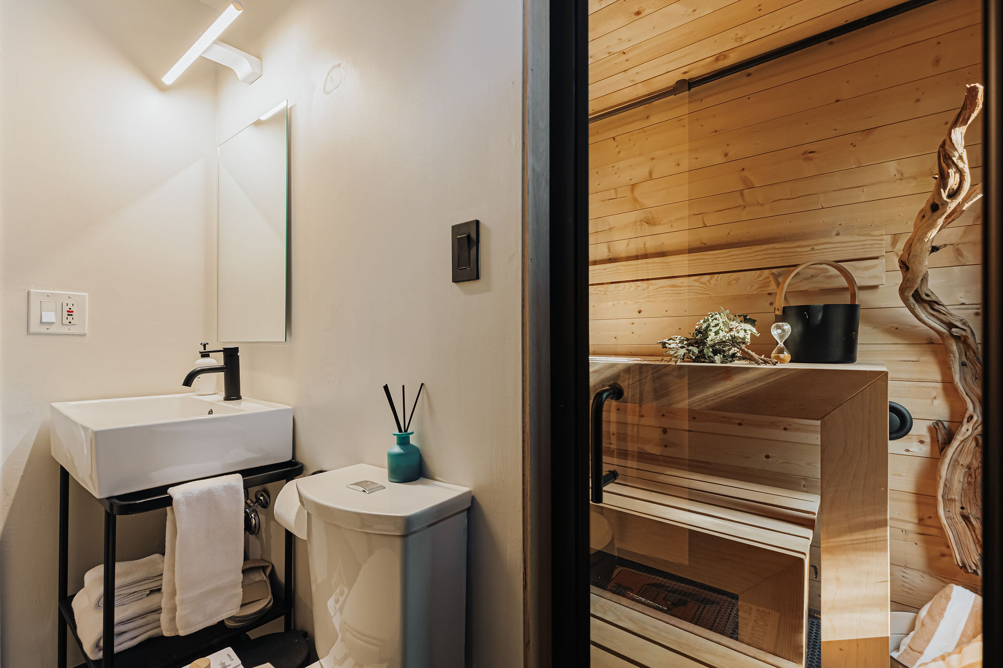Modern bath with private glass sauna for a spa-like stay
