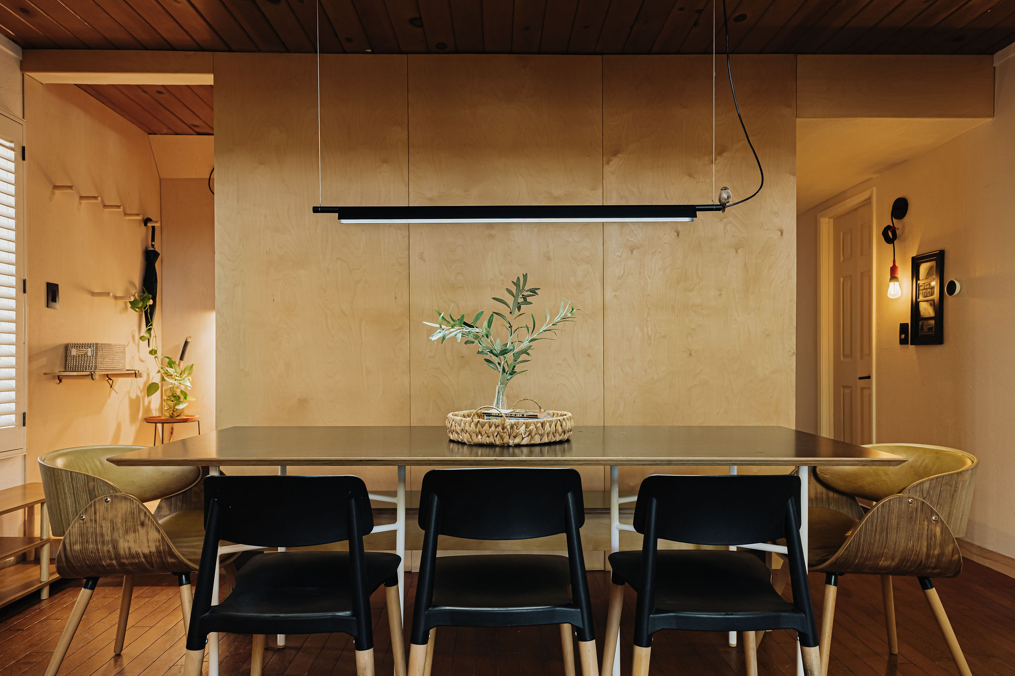Modern wood-accented dining room with designer lighting