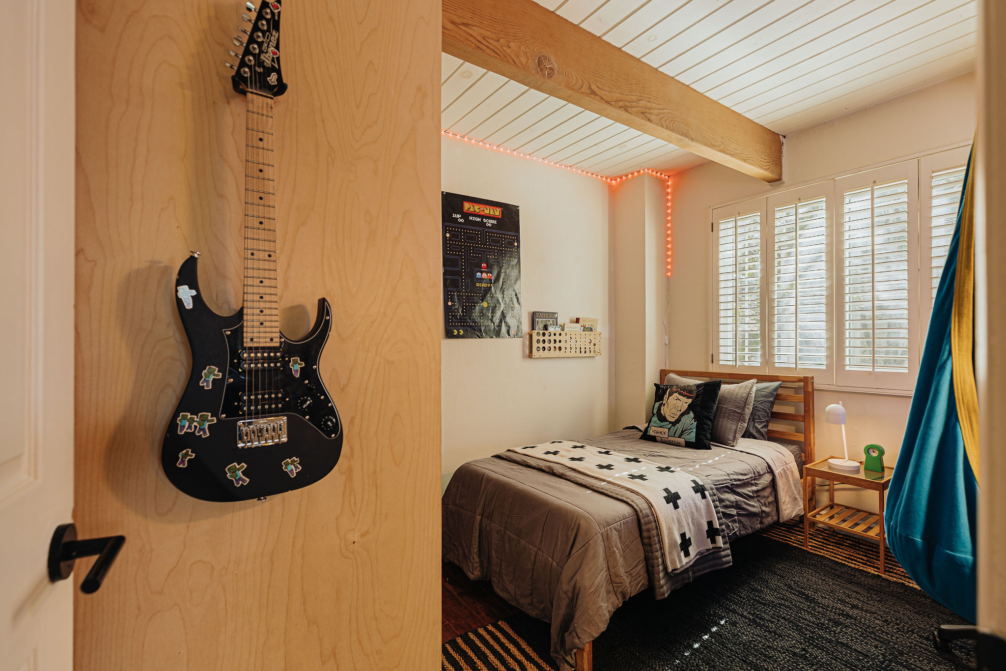 Cozy bedroom with wood beams, natural light, and playful modern style