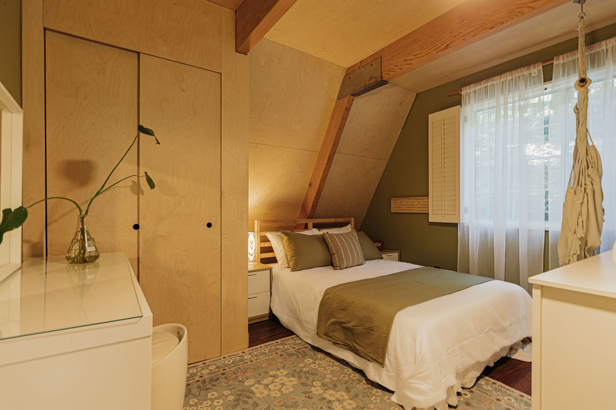 Cozy wood-beamed bedroom with soft light and stylish built-in storage