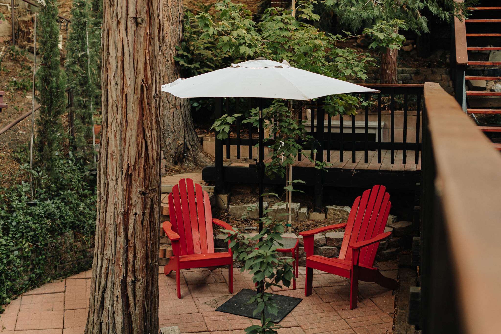 Private woodland patio with Adirondack chairs and shaded seating