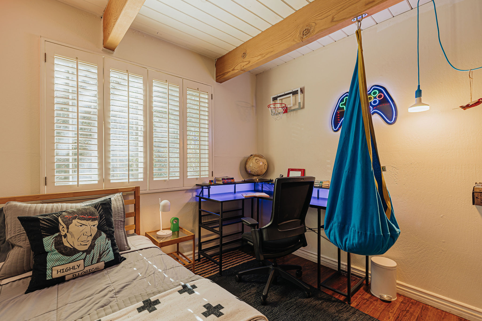 Fun bedroom with gaming desk, swing chair, and bright natural light
