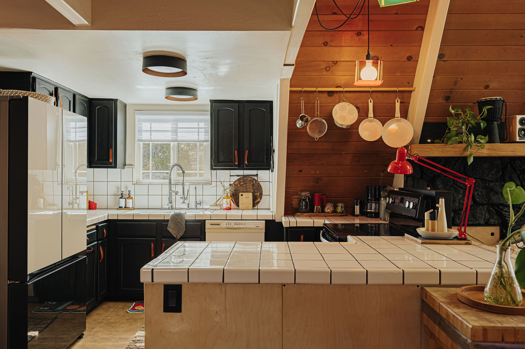 Warm rustic kitchen with tiled island, full appliances, and cozy cabin charm