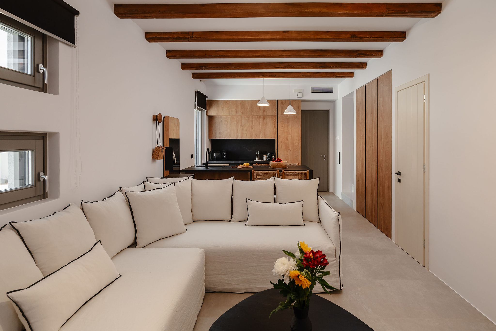 Bright open-plan lounge with designer kitchen and warm wood beams