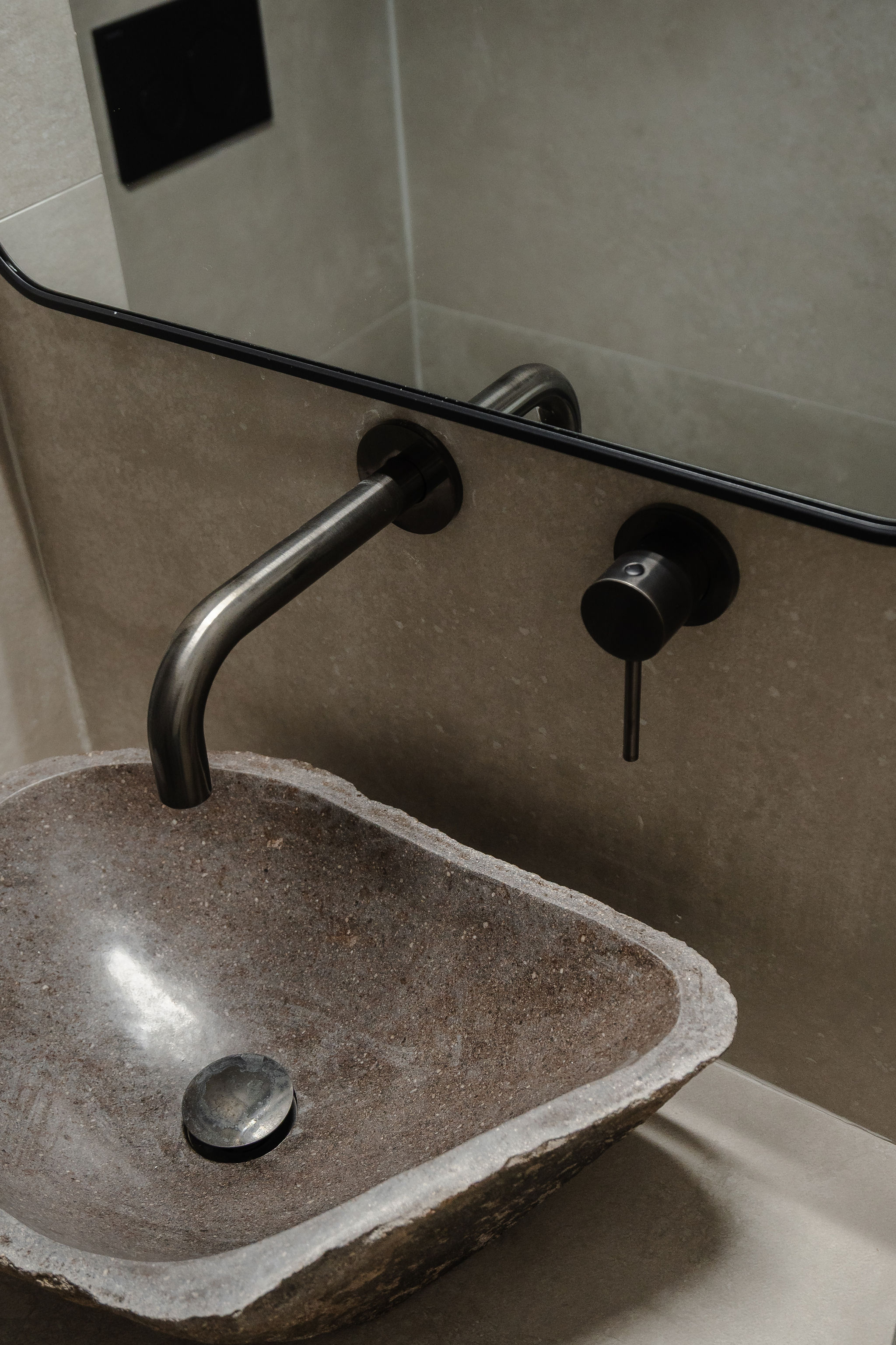 Rustic stone basin with sleek wall-mounted black faucet