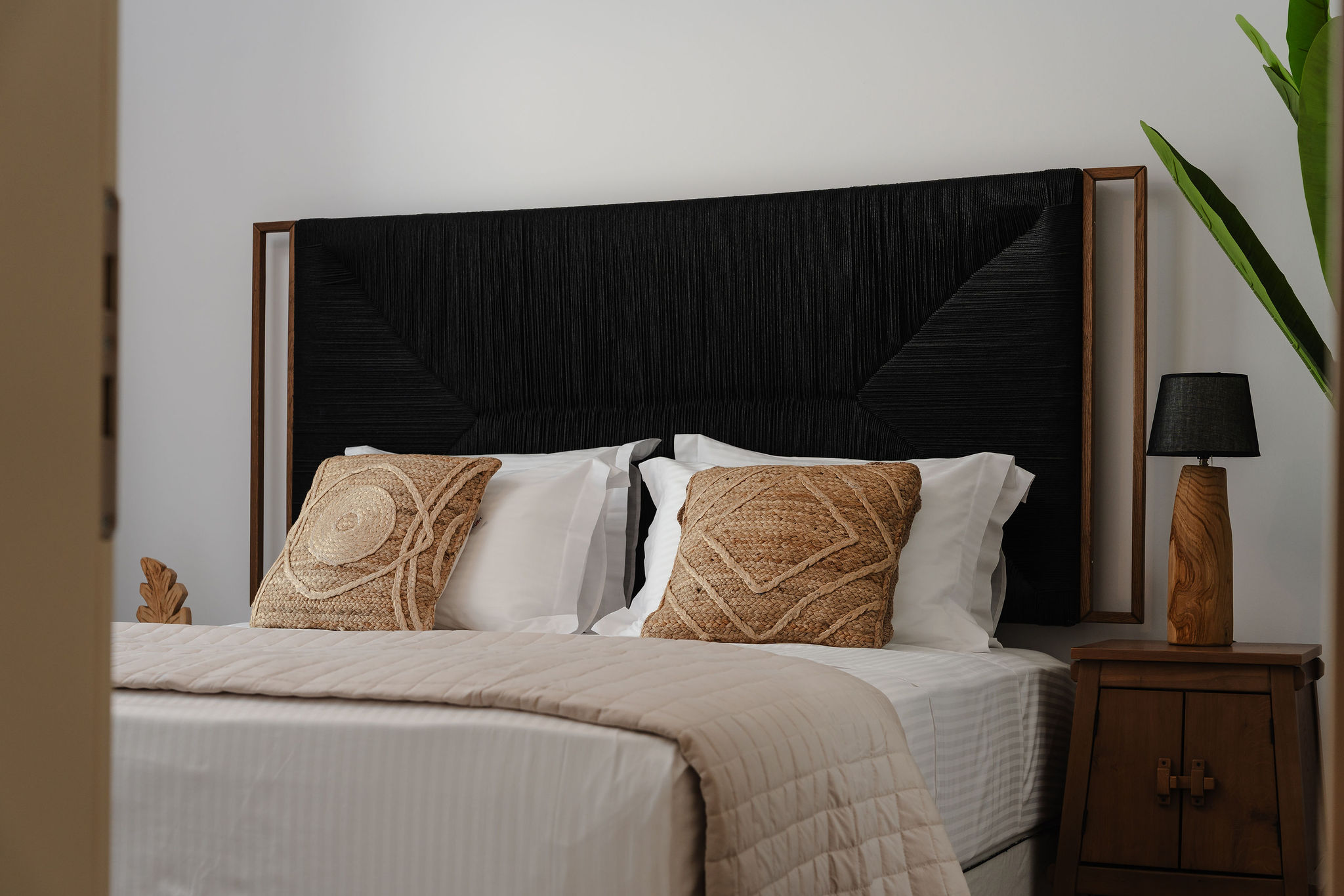 Elegant bedroom with bold headboard, crisp linens, and warm wood accents