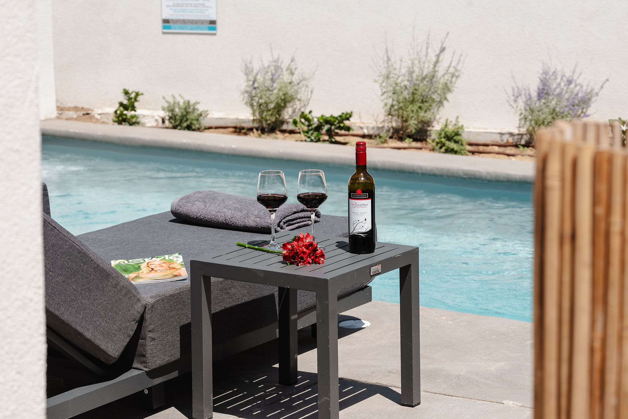 Private poolside lounge with chaise seating and wine for a relaxing stay