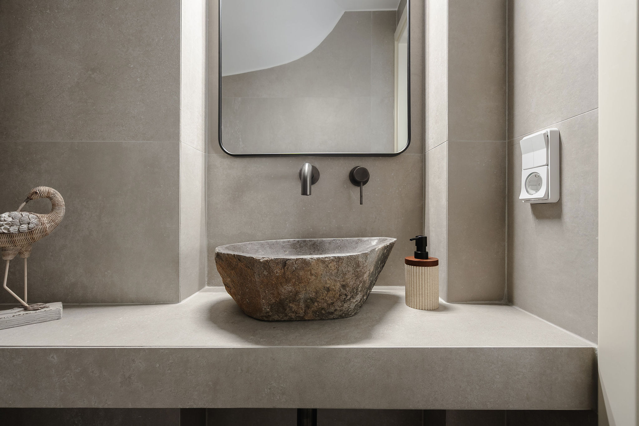 Spa-inspired bathroom with a striking stone sink and sleek modern finishes