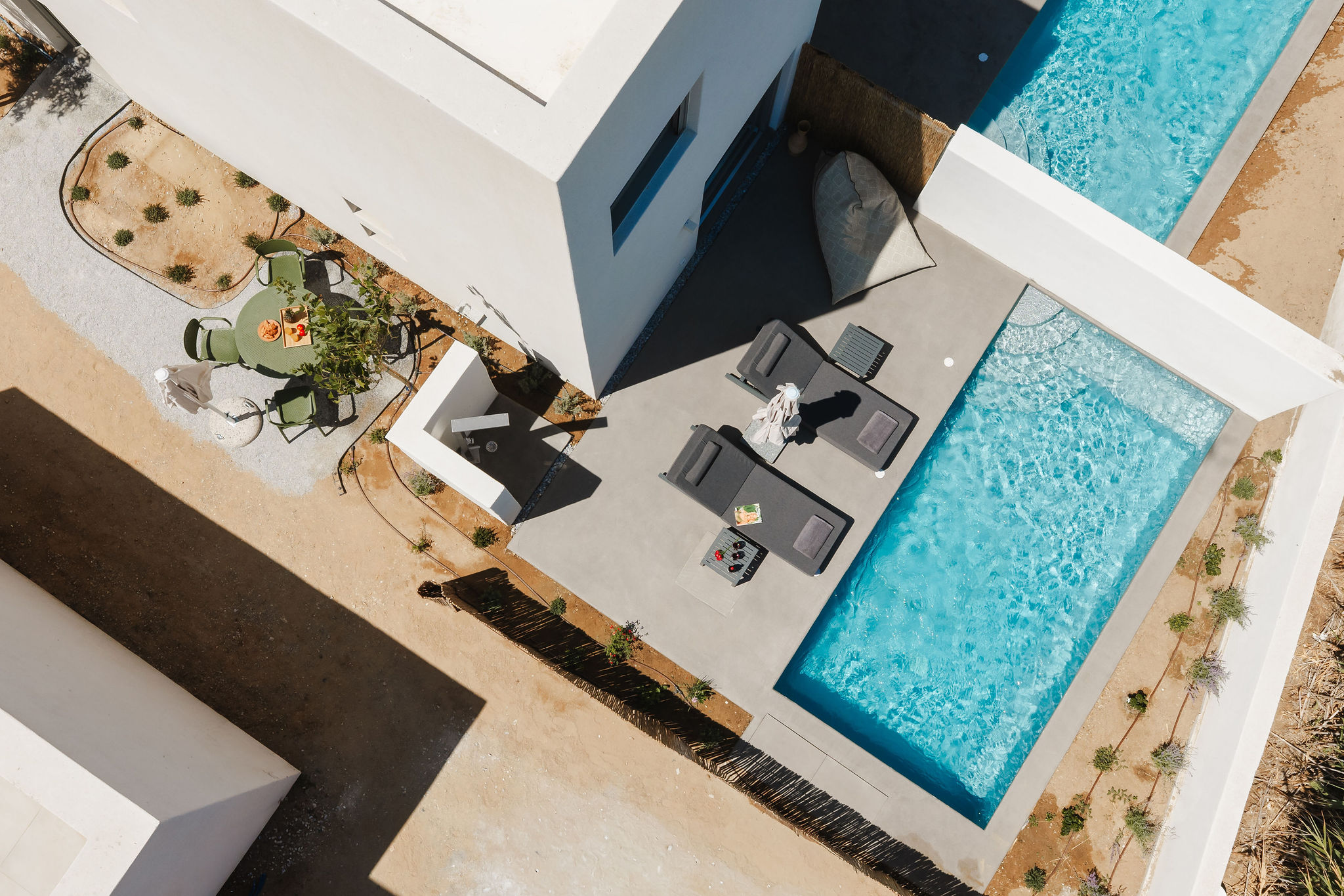 Modern villa with private pool, loungers, and sunny outdoor terrace