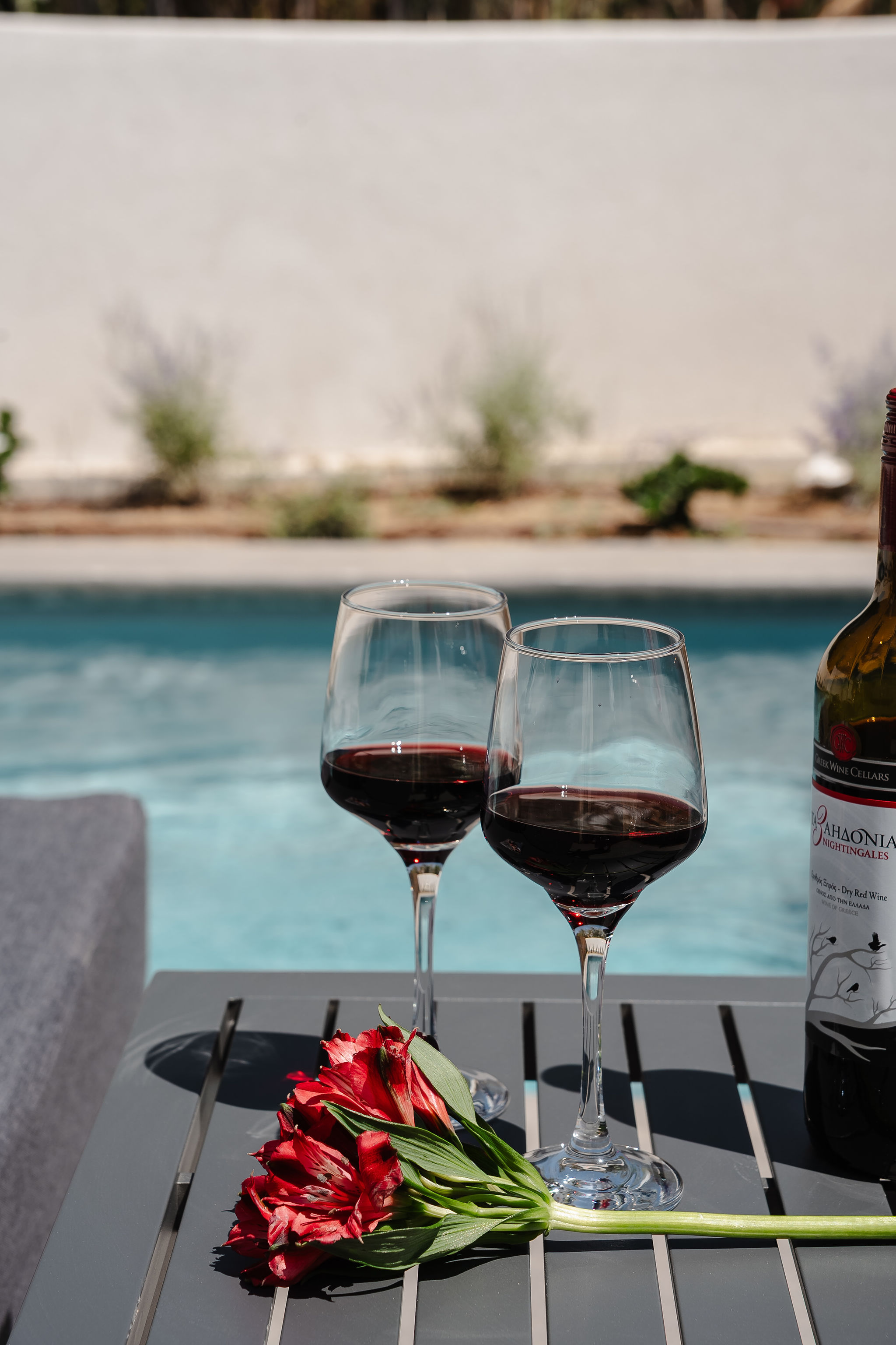 Relaxing poolside wine moment with flowers and tranquil outdoor charm