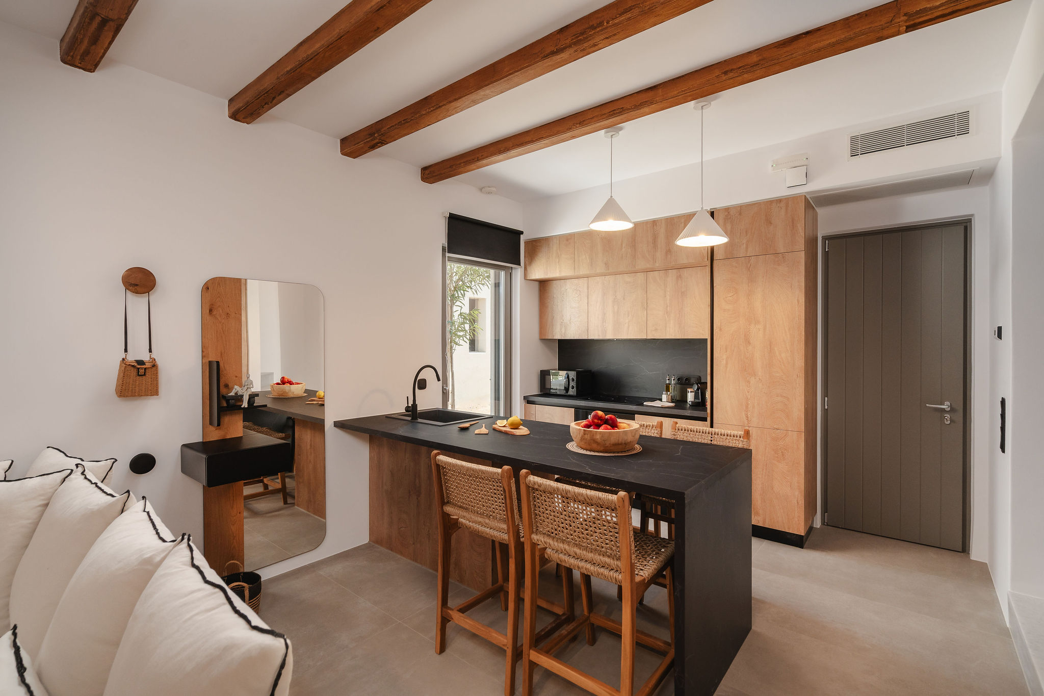 Modern kitchenette with wood accents, island seating, and rustic beams