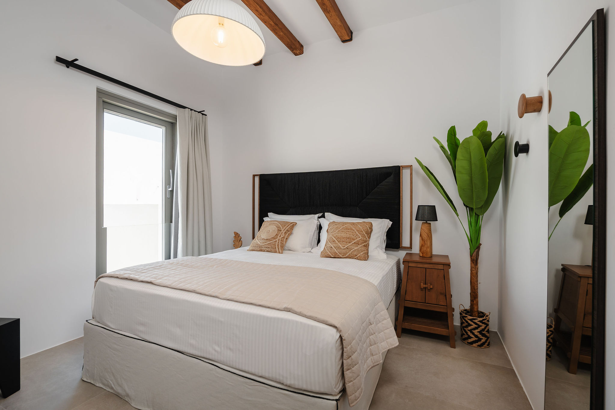 Bright, stylish bedroom with exposed beams and a serene modern design
