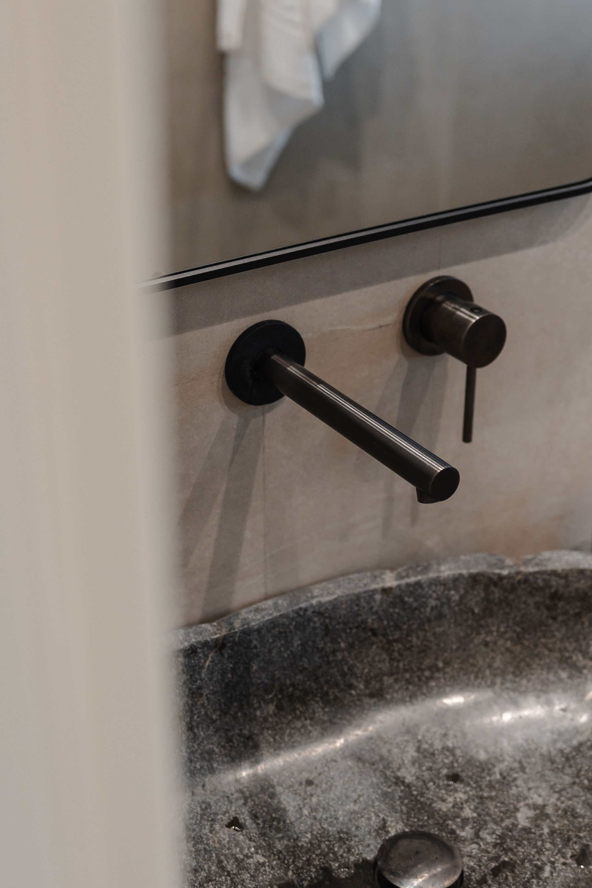 Modern bathroom detail with sleek black wall-mounted faucet