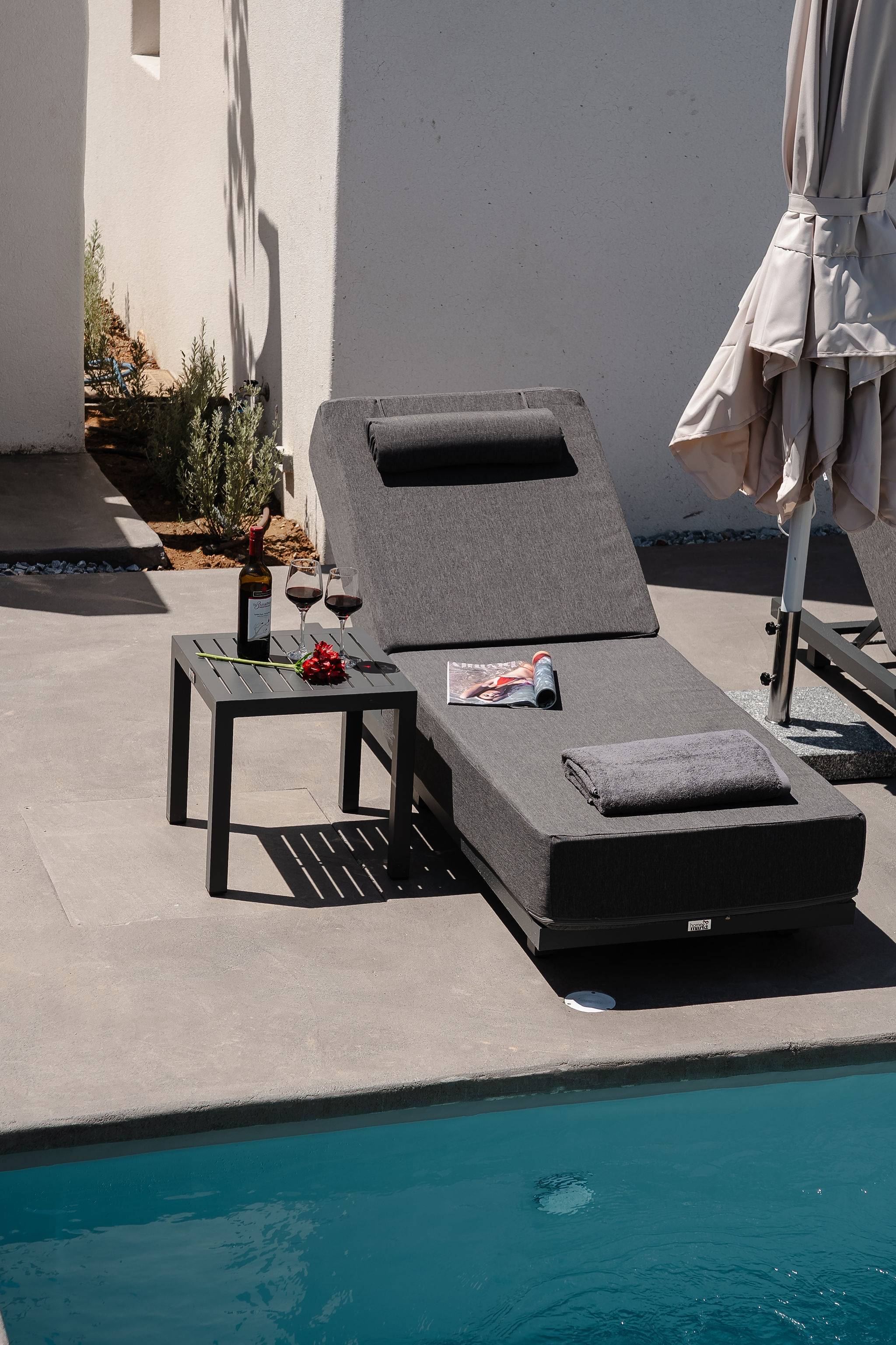 Stylish poolside sun lounger with wine and serene modern resort vibes