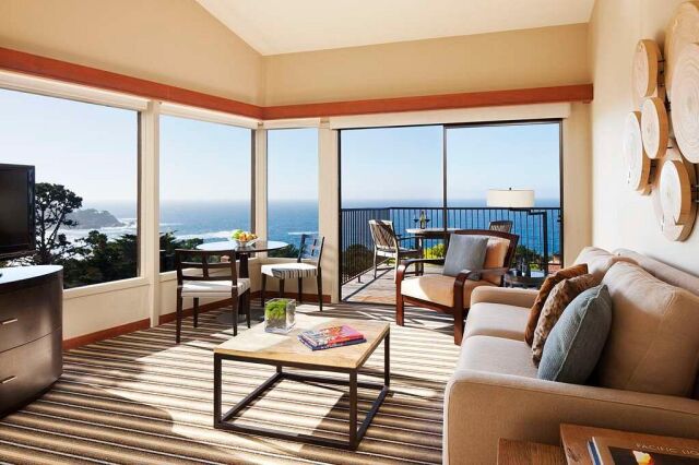 Bright oceanview living room with private balcony and cozy seating
