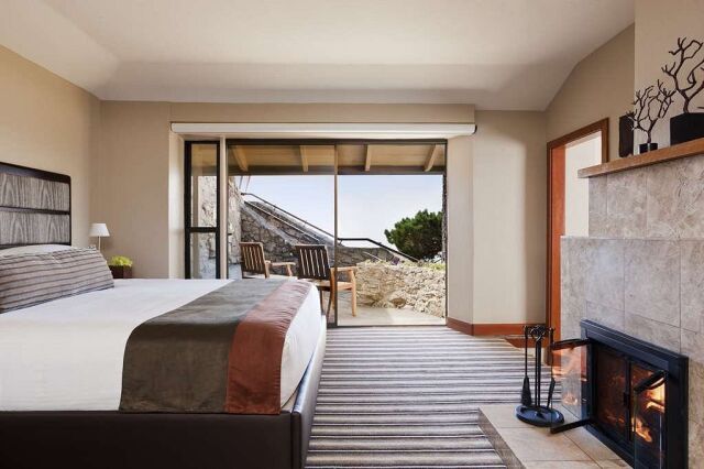Cozy fireplace bedroom with patio seating and scenic outdoor views