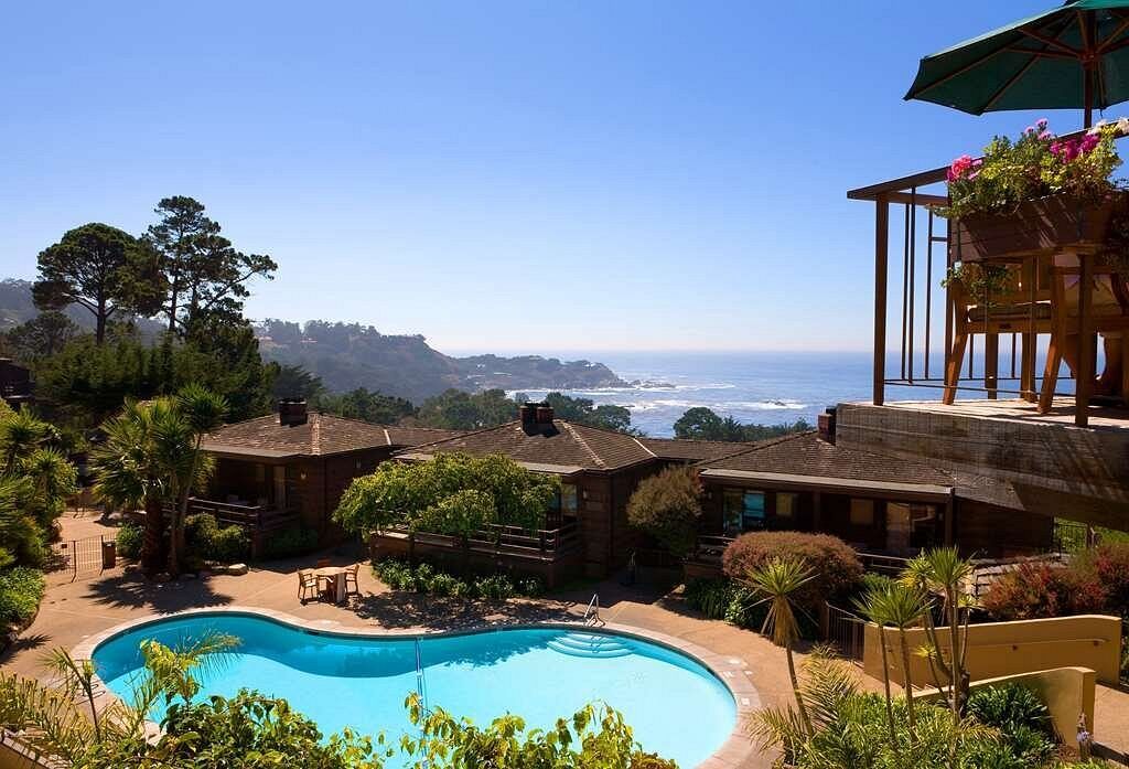 Ocean-view pool oasis with sunny patio dining and coastal scenery