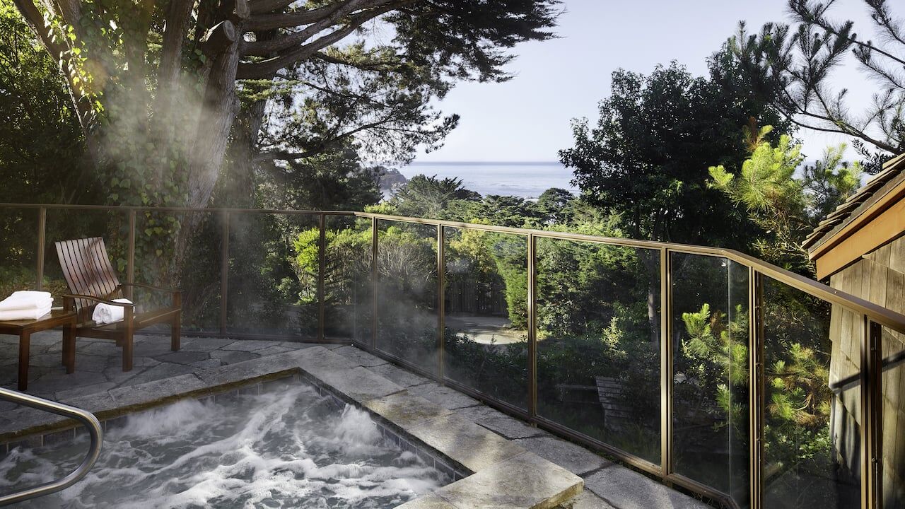 Private hot tub with serene ocean views and lush garden surroundings