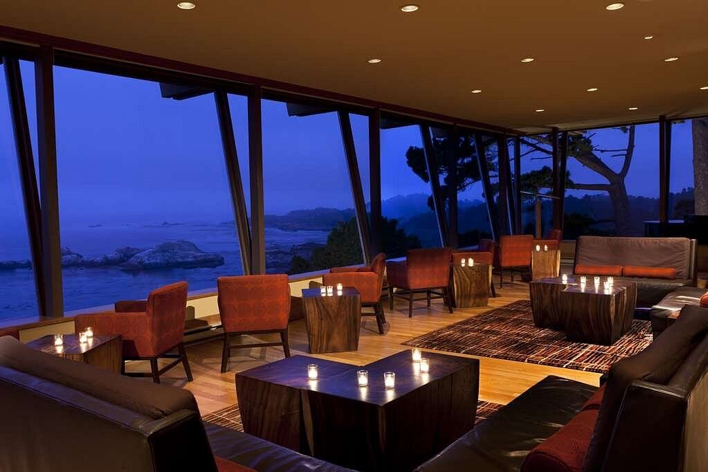 Elegant oceanview lounge with floor-to-ceiling windows at sunset