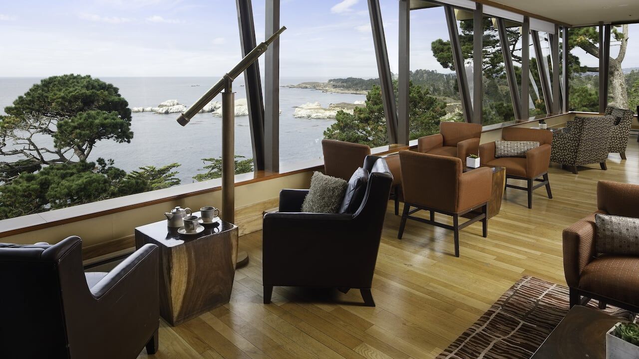 Elegant oceanview lounge with floor-to-ceiling windows and cozy seating