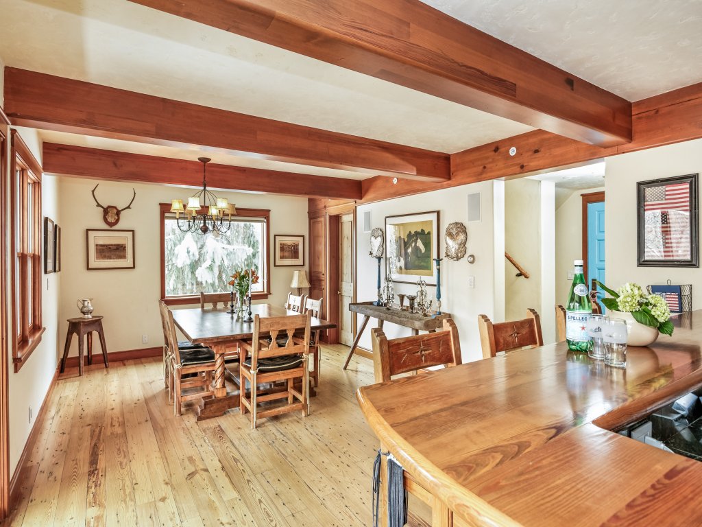 Rustic dining room with exposed beams, big windows, and warm wood details
