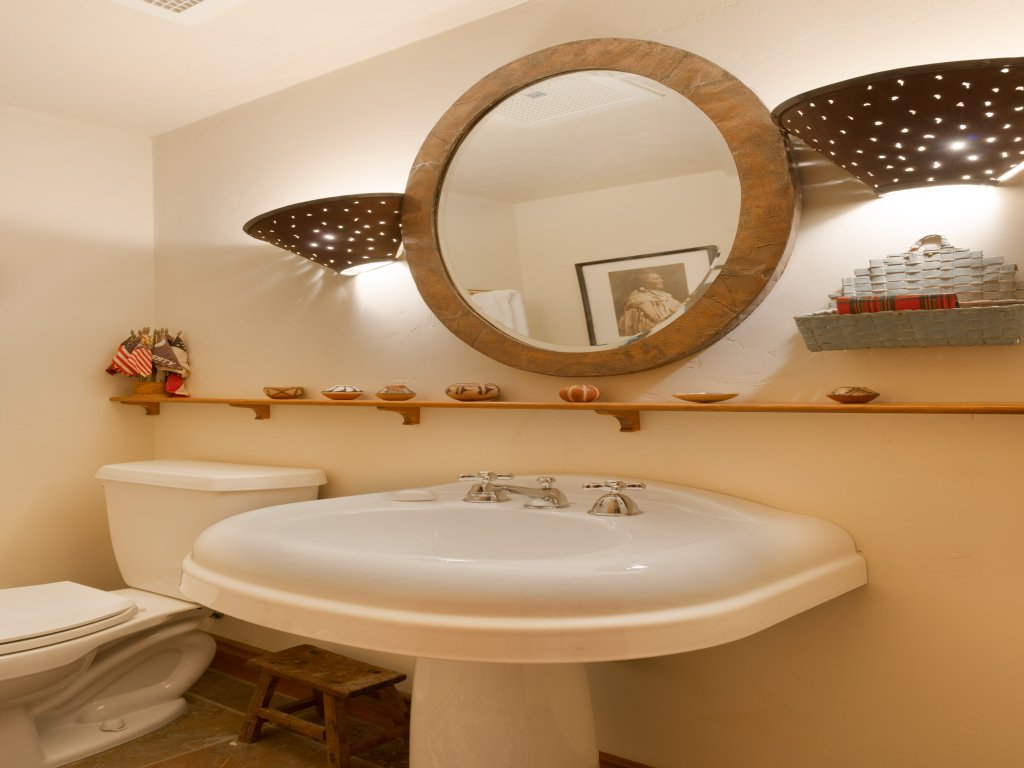 Warm, stylish bathroom with statement lighting and a large vanity mirror