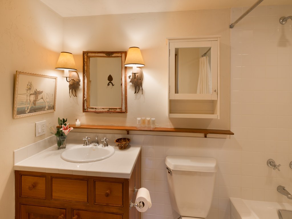 Warm, rustic bathroom with tub-shower combo and charming wood accents