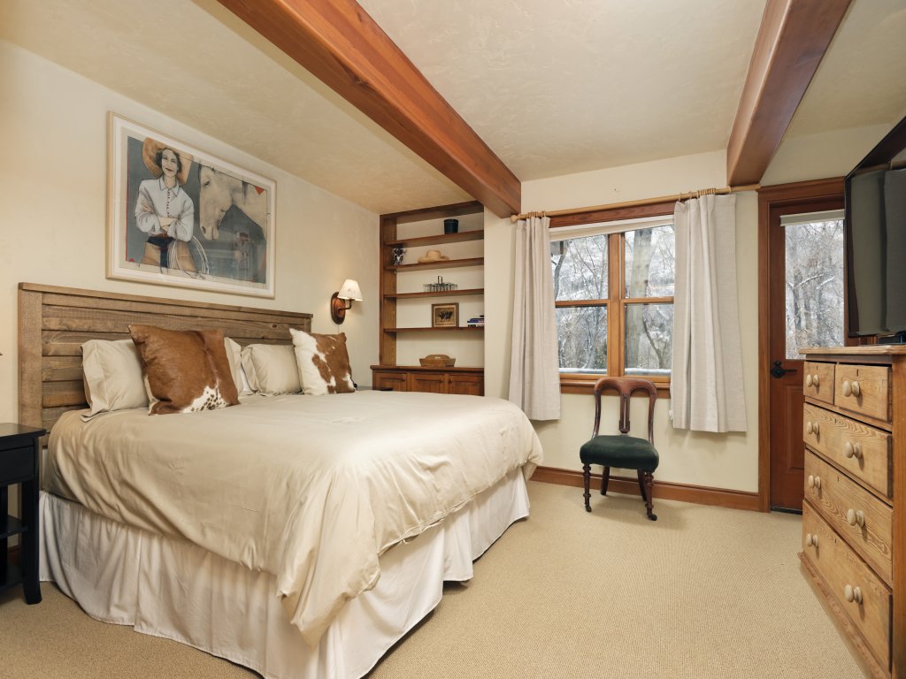 Cozy rustic king bedroom with woodland views and warm wood details