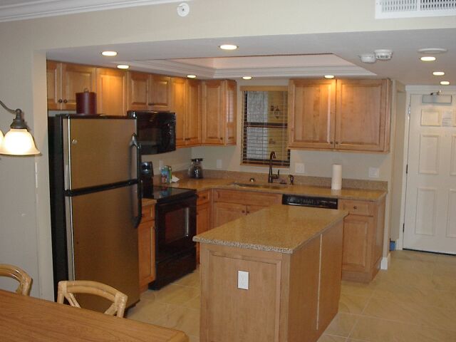 Bright full kitchen with granite counters, island, and ample cabinet space