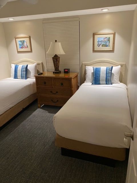 Cozy double-bed room with warm lighting and crisp, hotel-style bedding