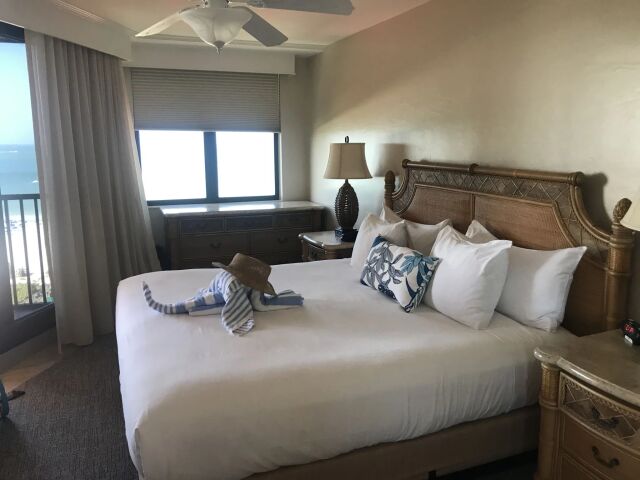 Cozy king bedroom with ocean-view balcony and tropical-inspired decor