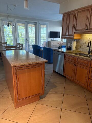 Bright open kitchen with island, dining nook, and sunny living space