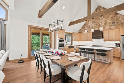 A ring chandelier and wood-paneled entry doors frame the dining table, details that make every family dinner feel a little more special.