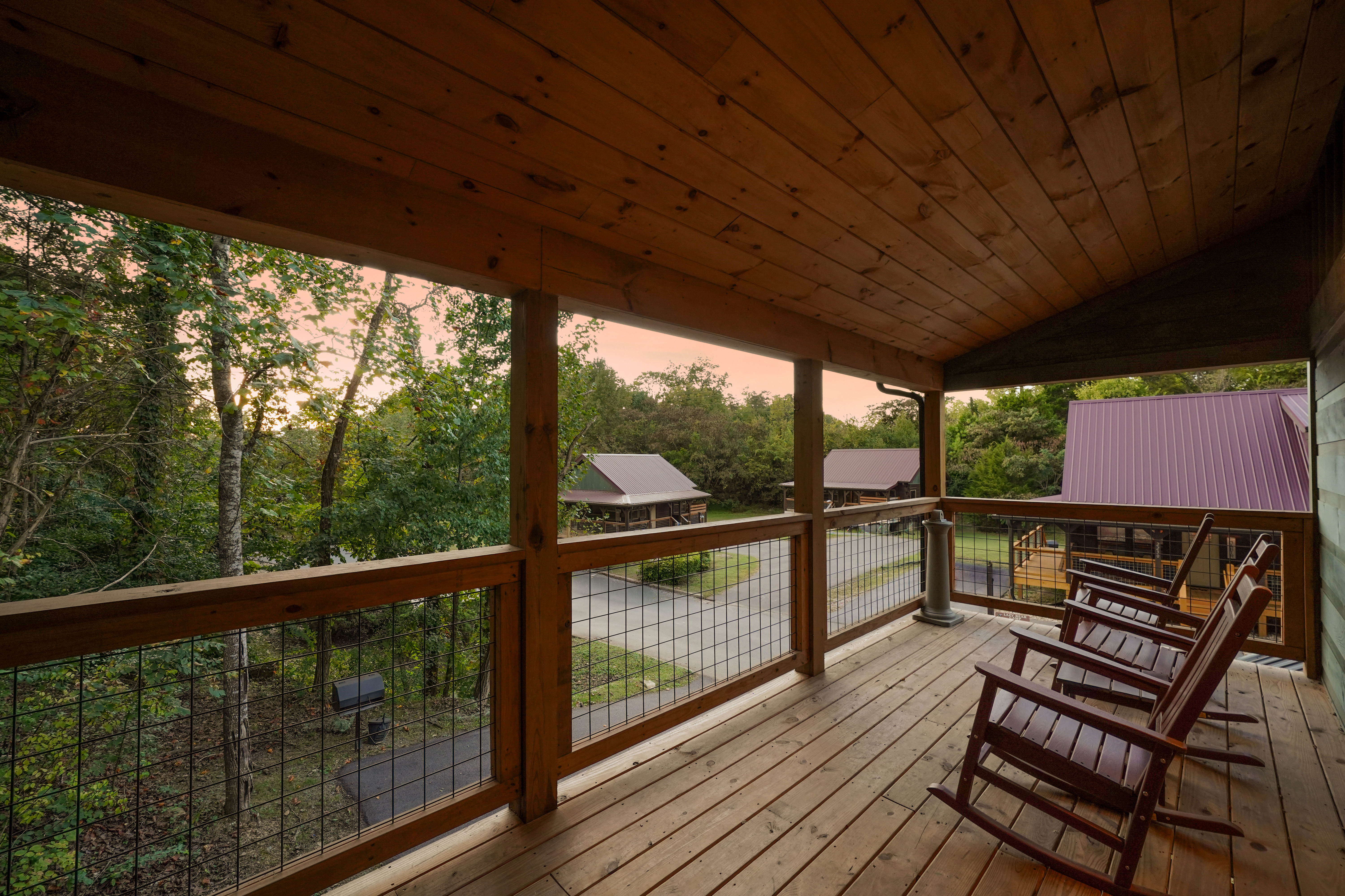Relax on the covered porch with rocking chairs and peaceful wooded views