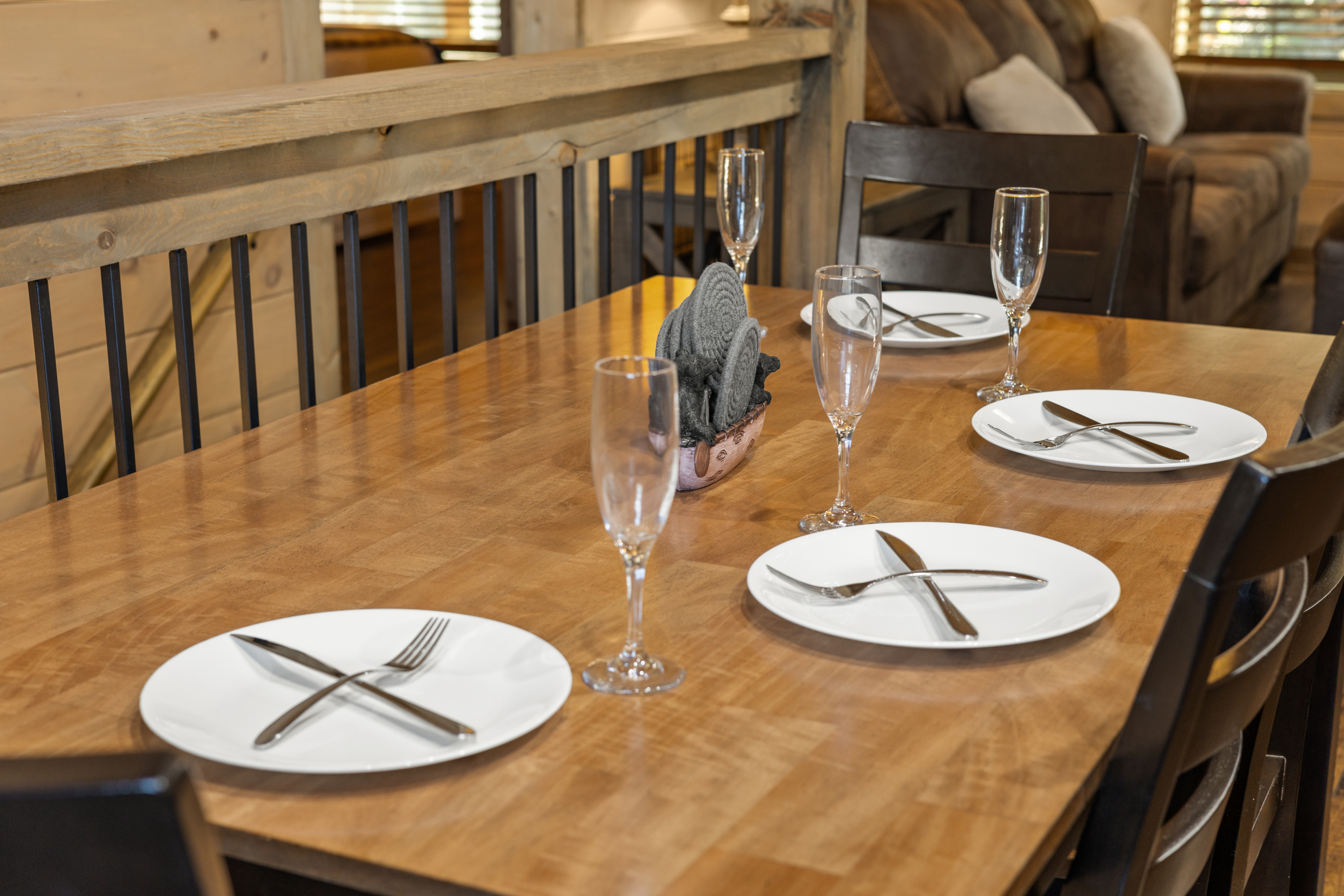 Rustic wood dining area set for four beside a cozy cabin living space