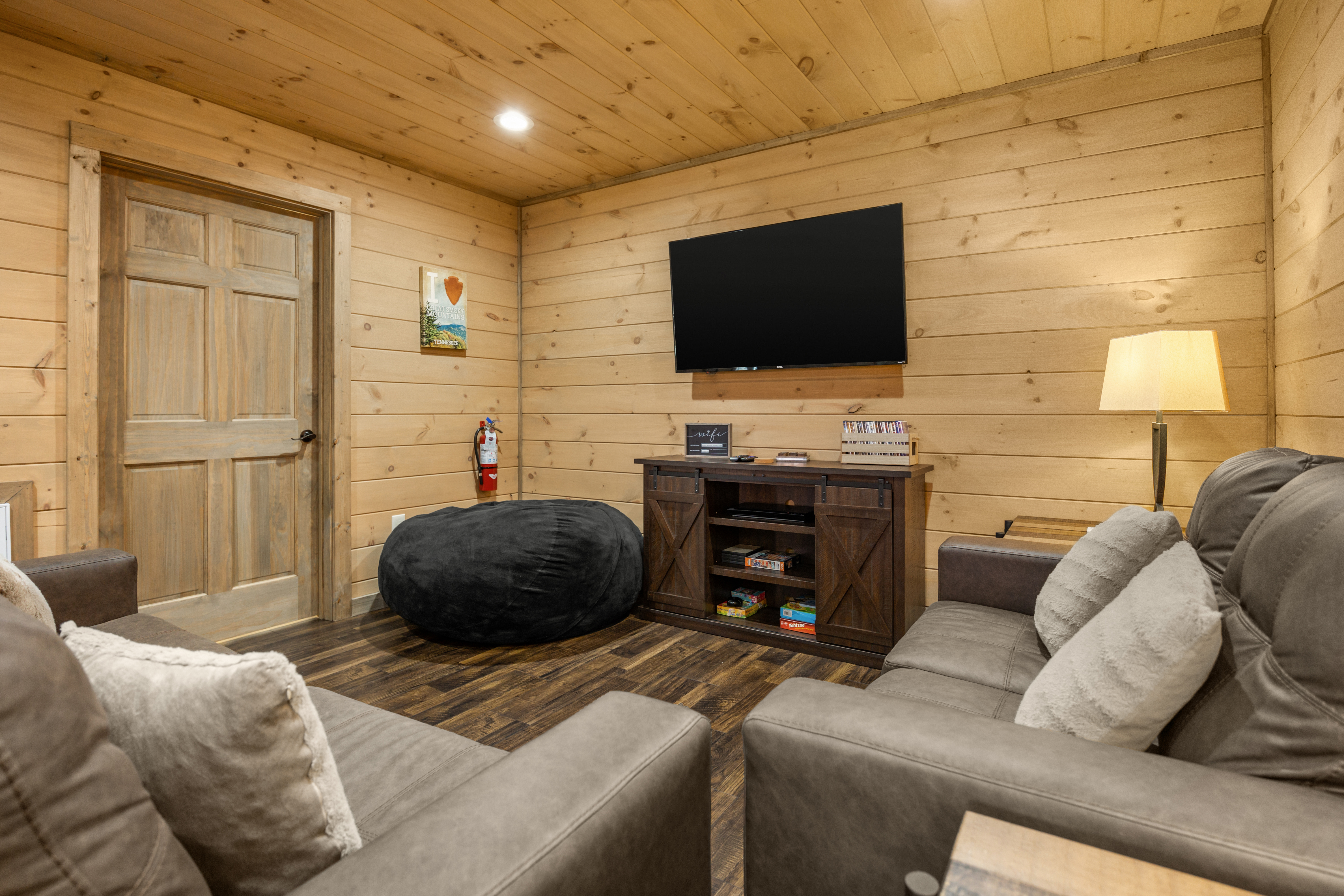 Cozy cabin-style media room with plush seating and large TV