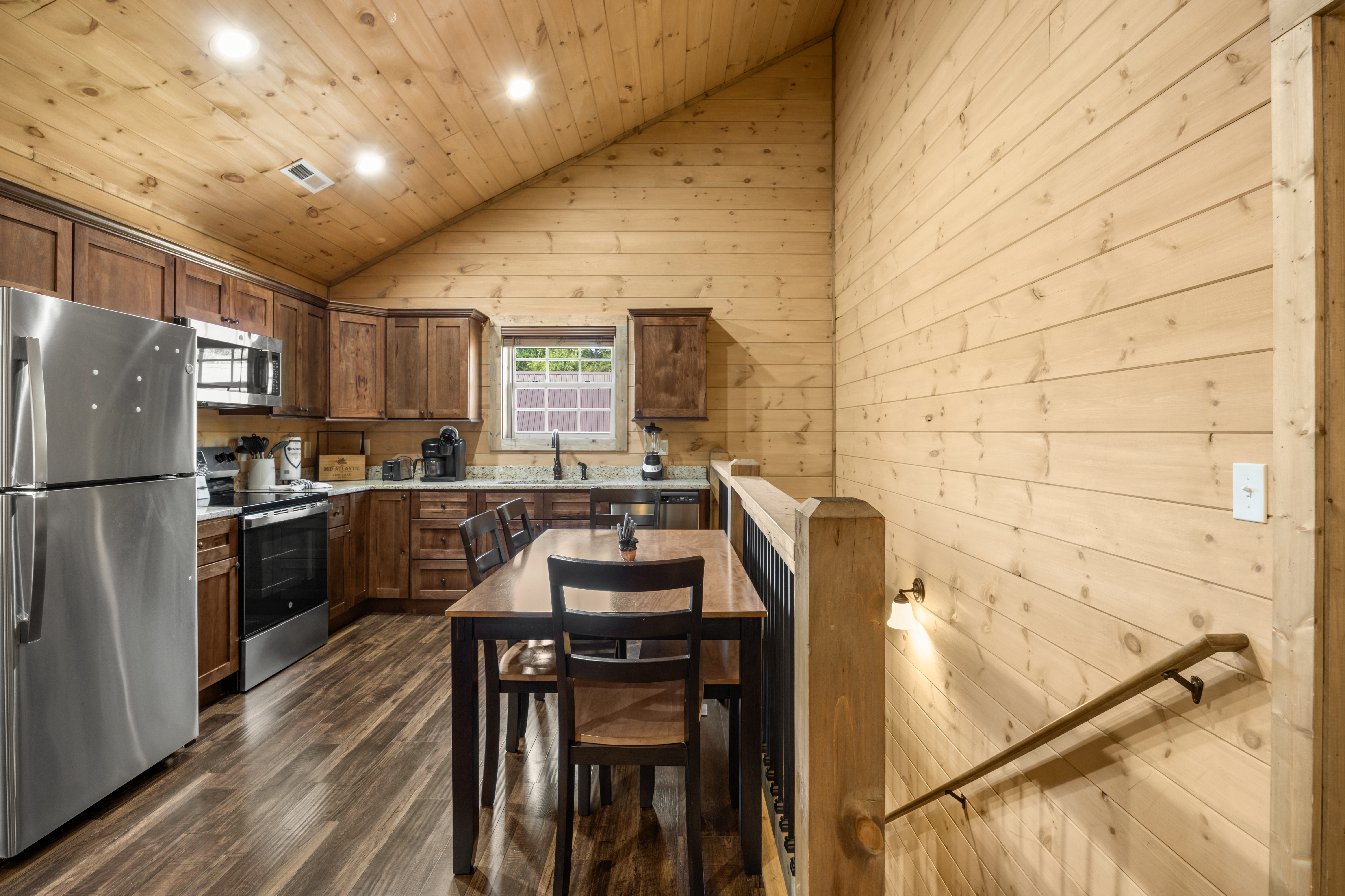 Cozy cabin kitchen with vaulted wood ceilings and dining for 4