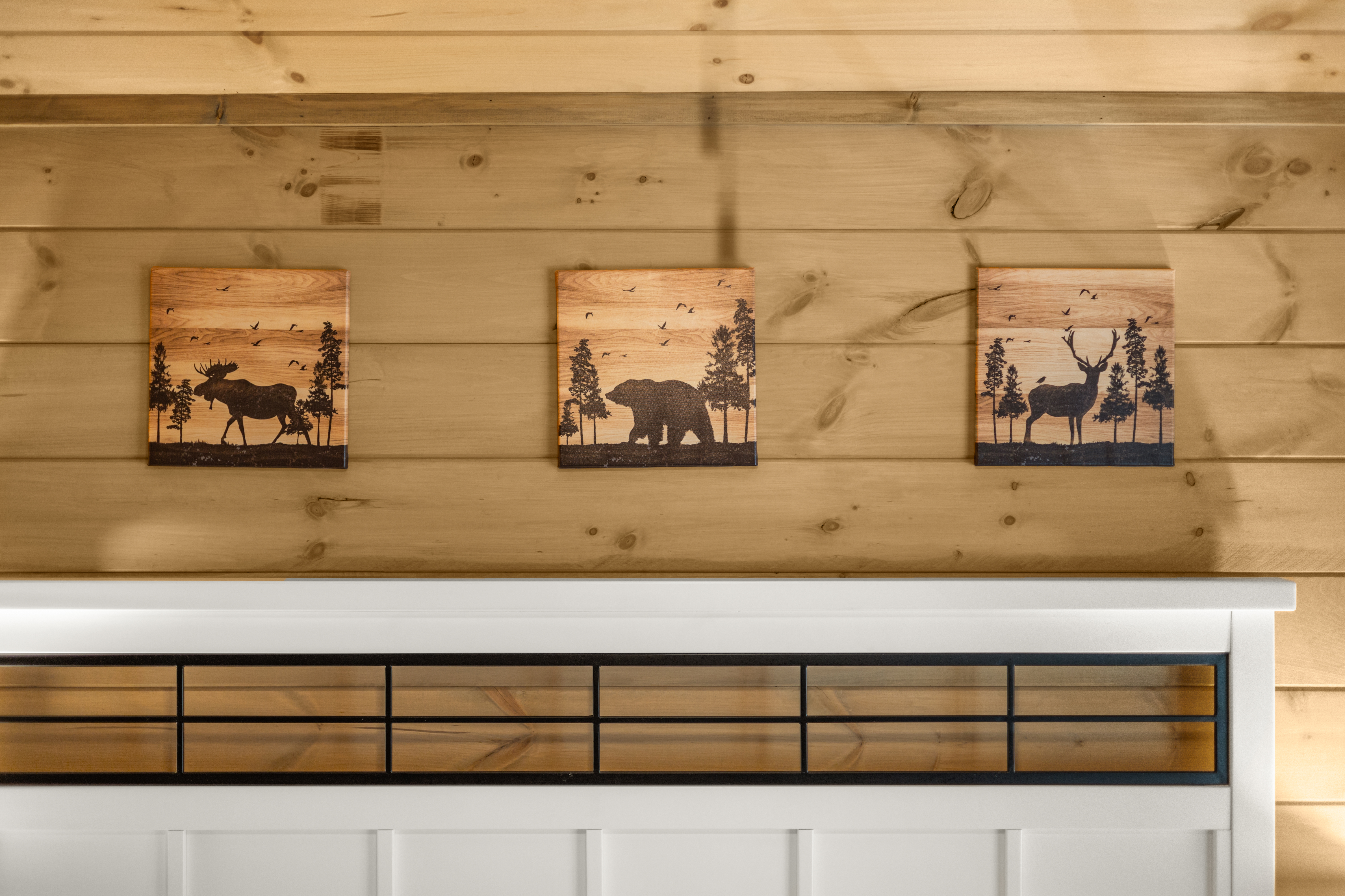 Rustic cabin bedroom with warm wood walls and charming wildlife decor