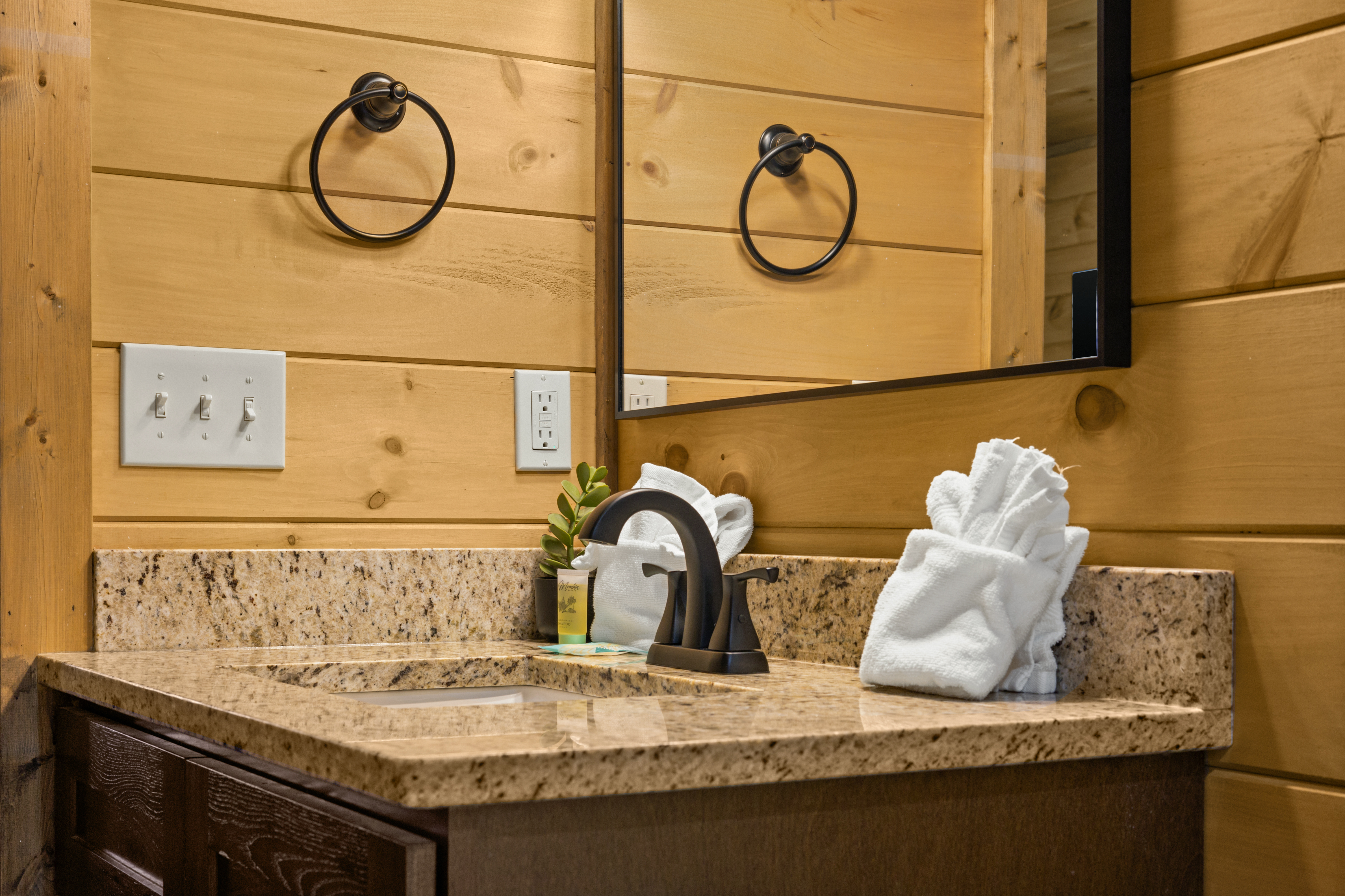 Rustic bathroom vanity with granite counter and warm cabin charm
