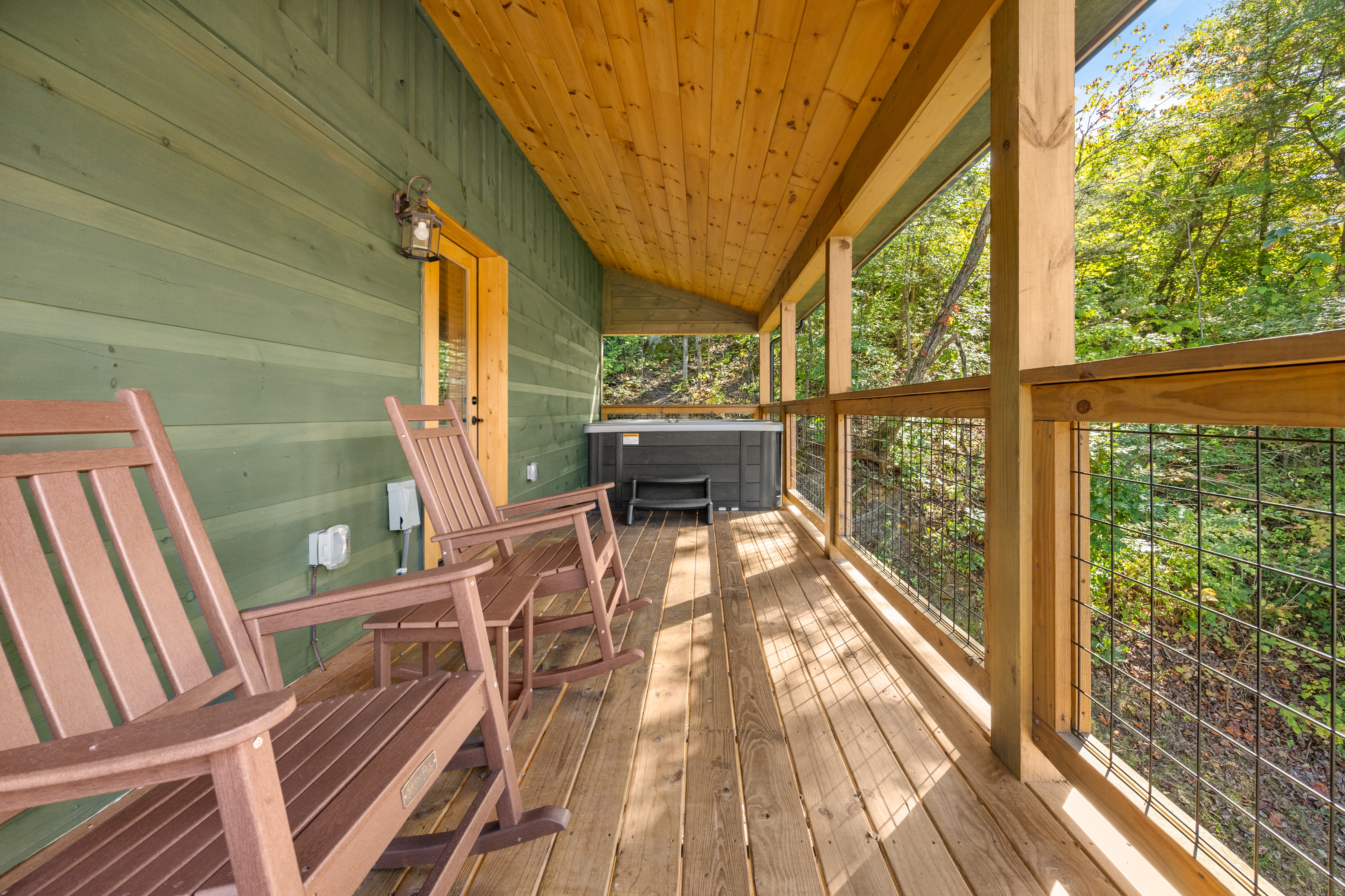 Covered forest-view porch with rocking chairs and private hot tub