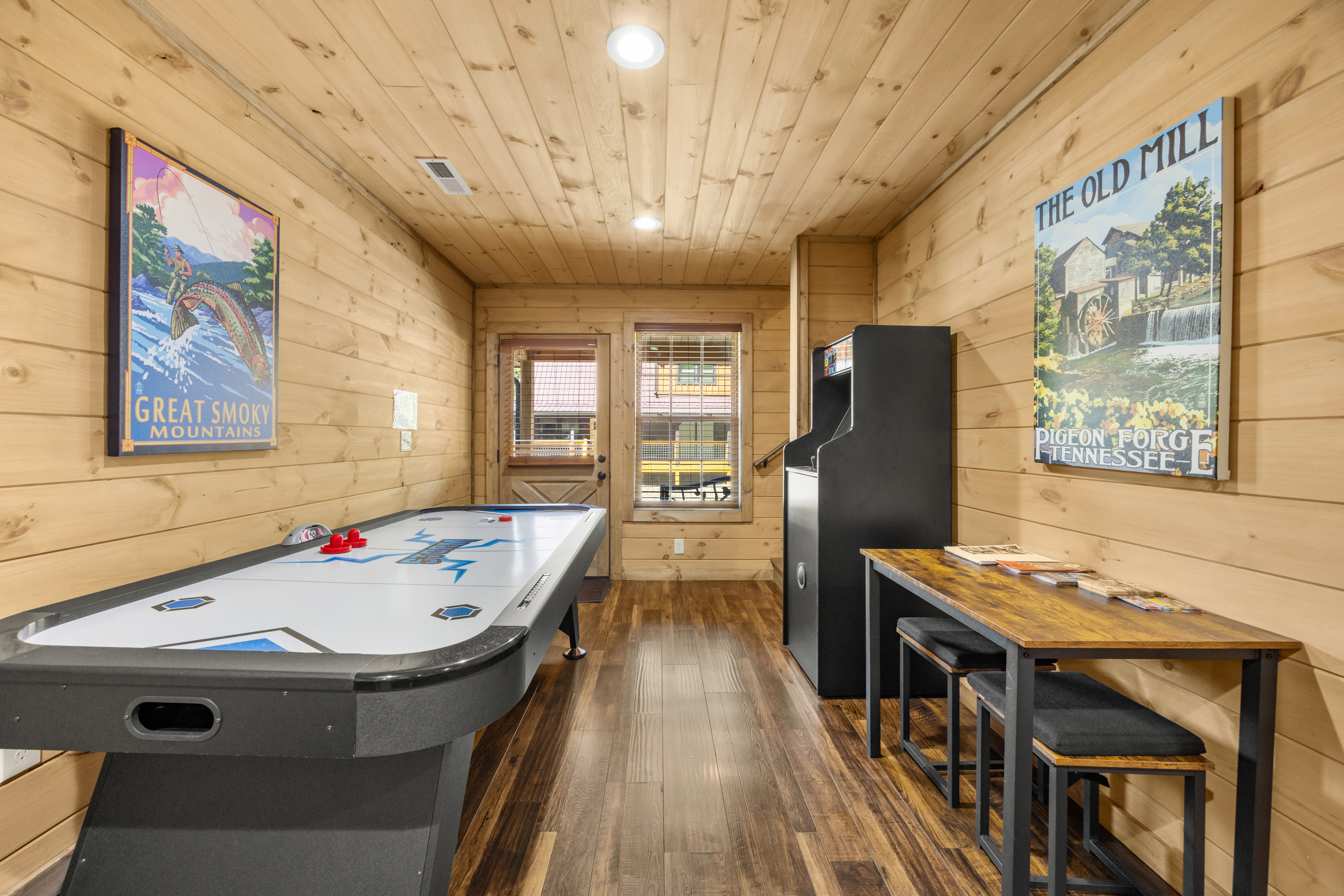 Cozy cabin game room with air hockey, arcade fun, and rustic charm
