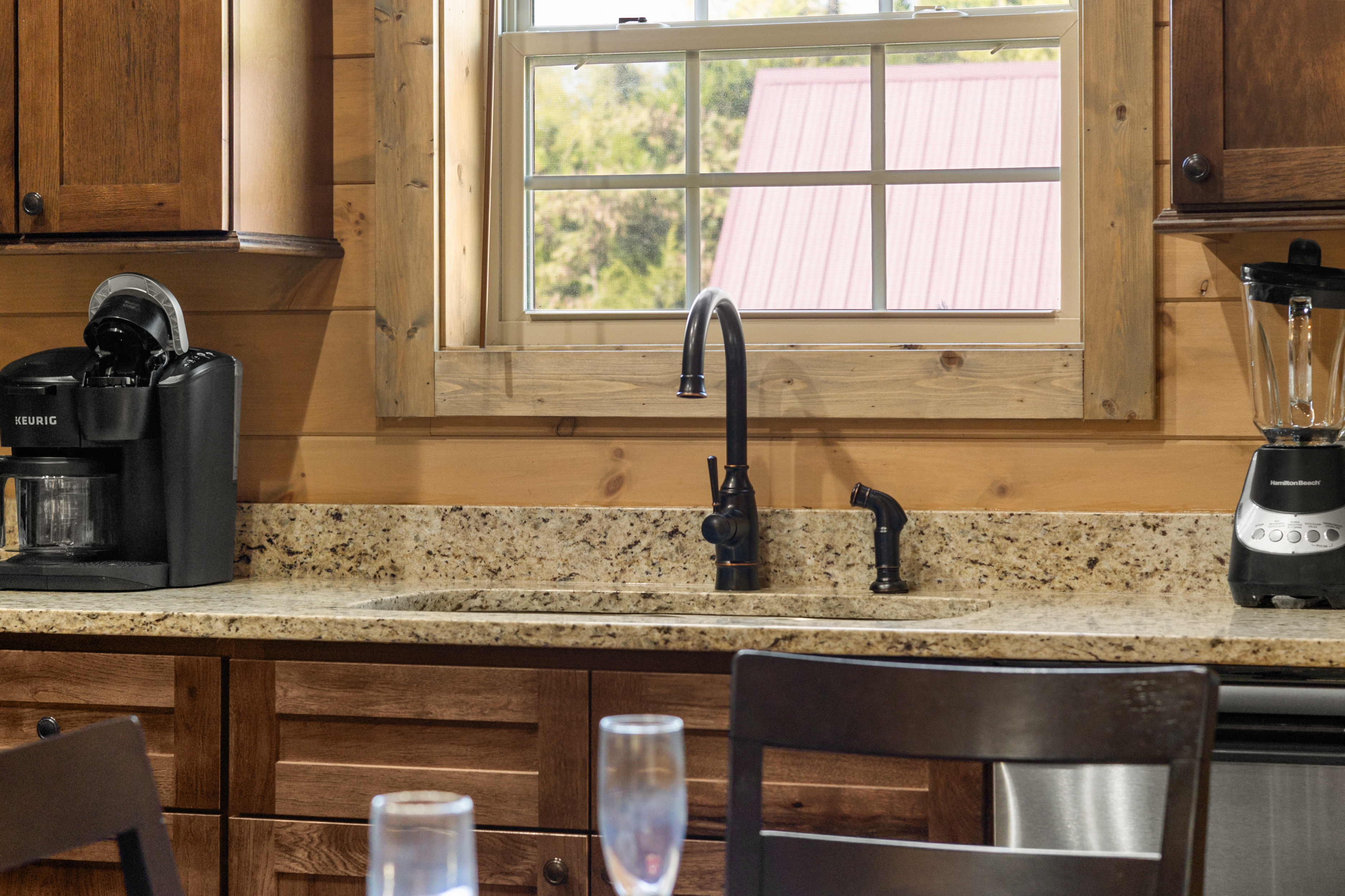 Cozy cabin kitchen with granite counters, coffee maker, and scenic window view