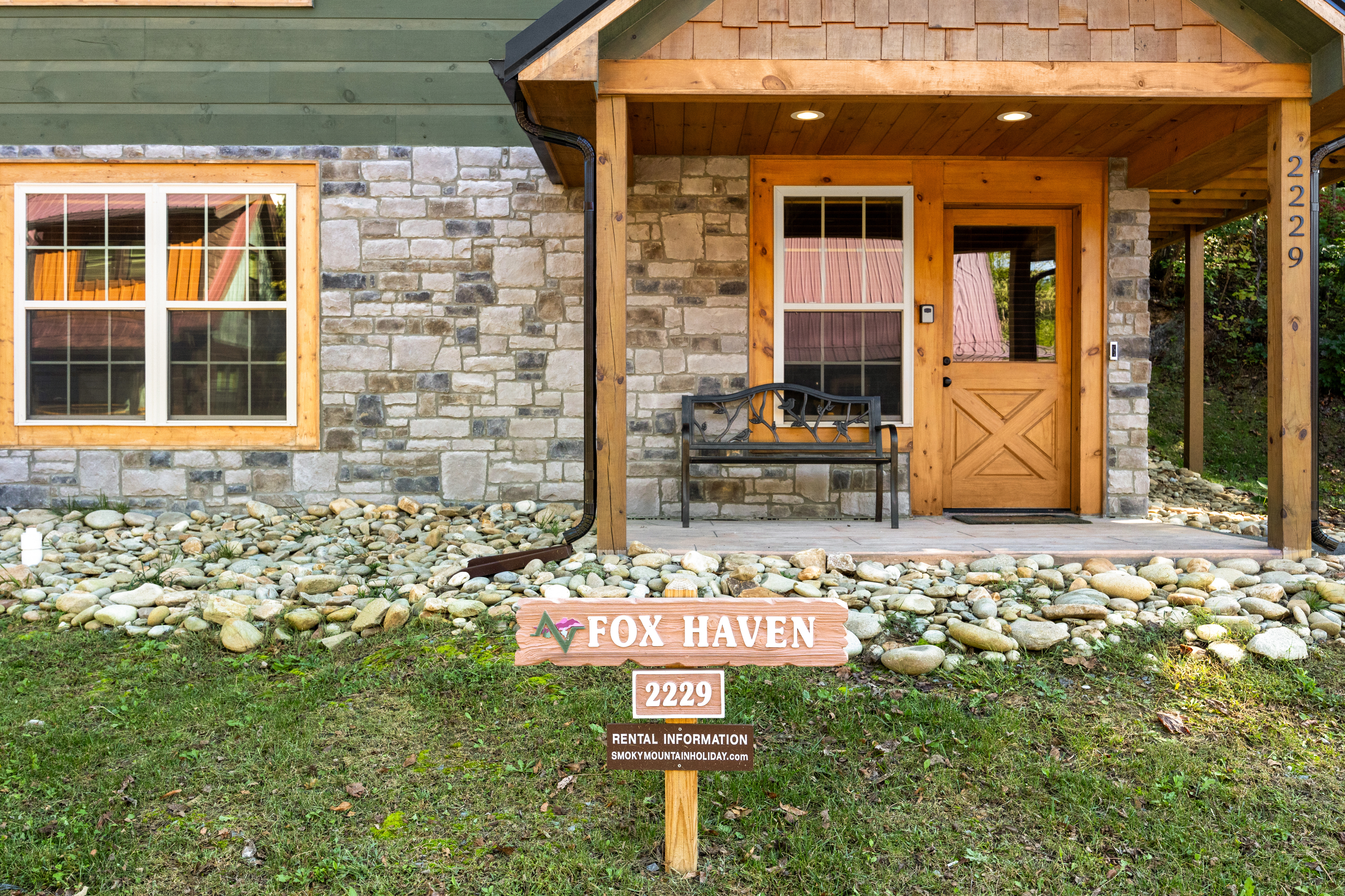 Inviting stone-and-wood cabin entry with covered porch and mountain charm