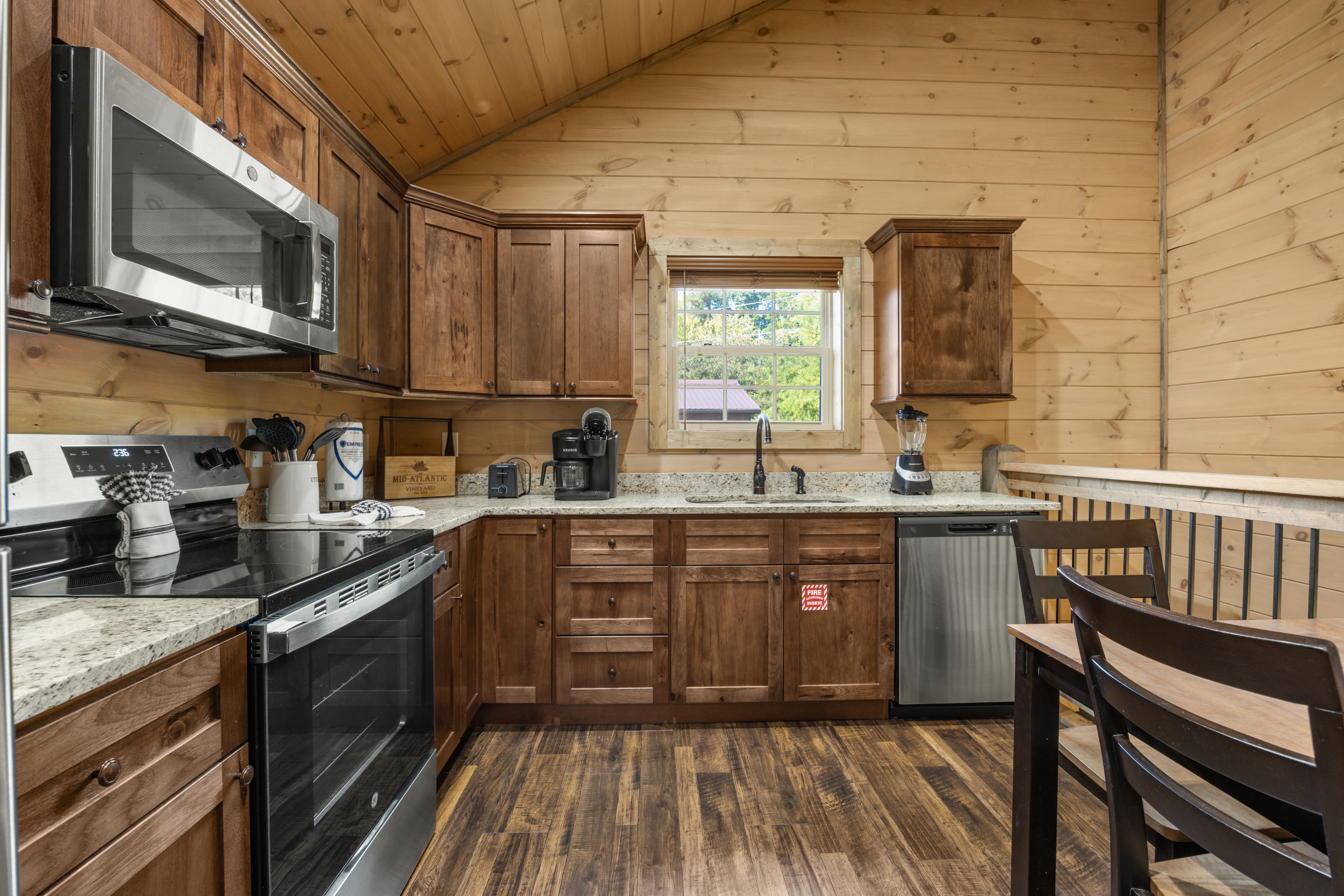 Cozy cabin kitchen with wood finishes, bar seating, and stainless appliances