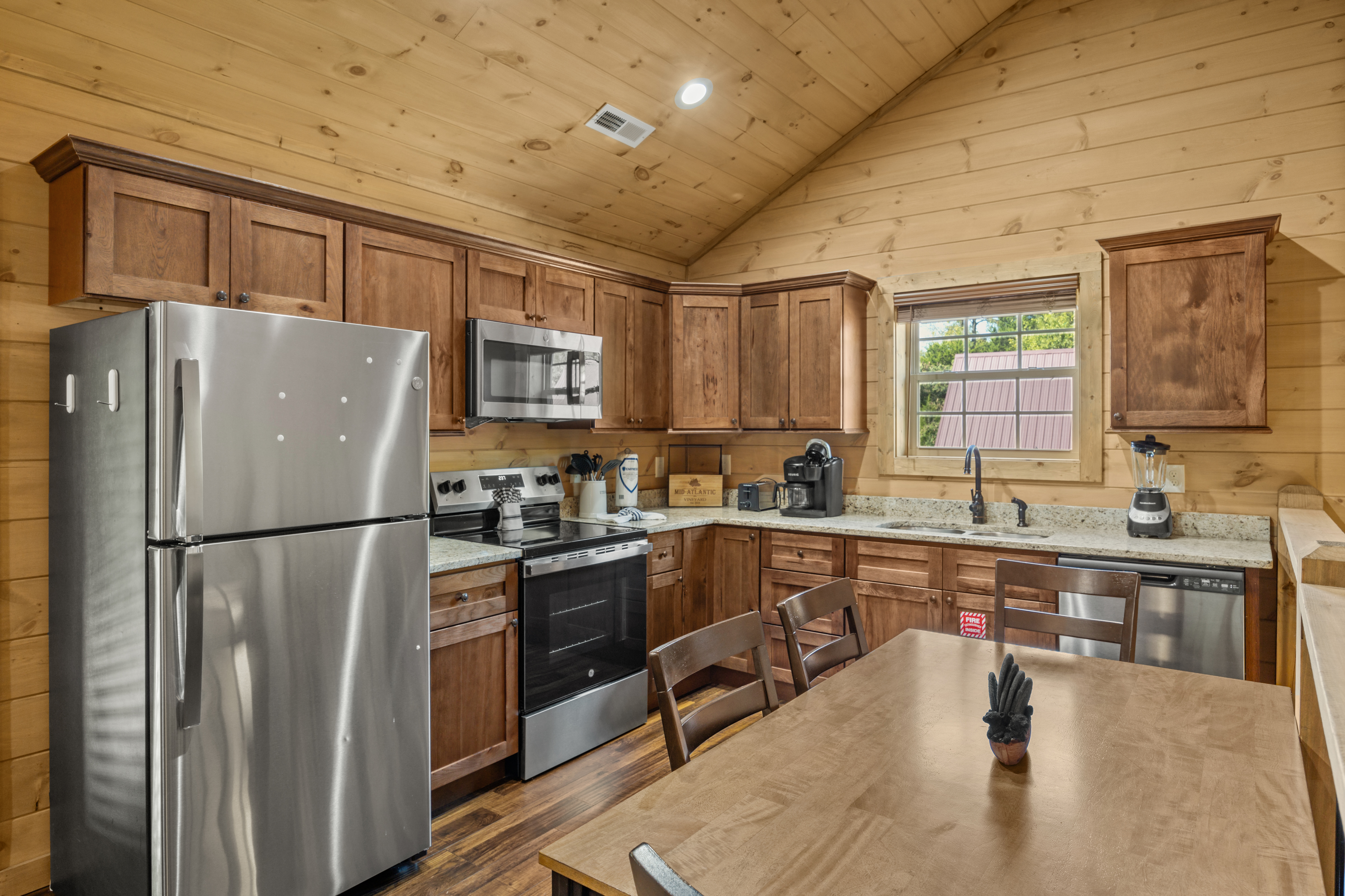 Cozy wood-lined kitchen with stainless appliances and dining space