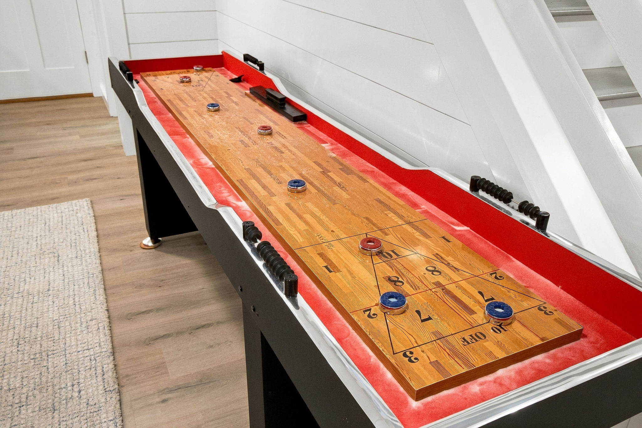 Challenge friends to a game of shuffleboard in this stylish rec room