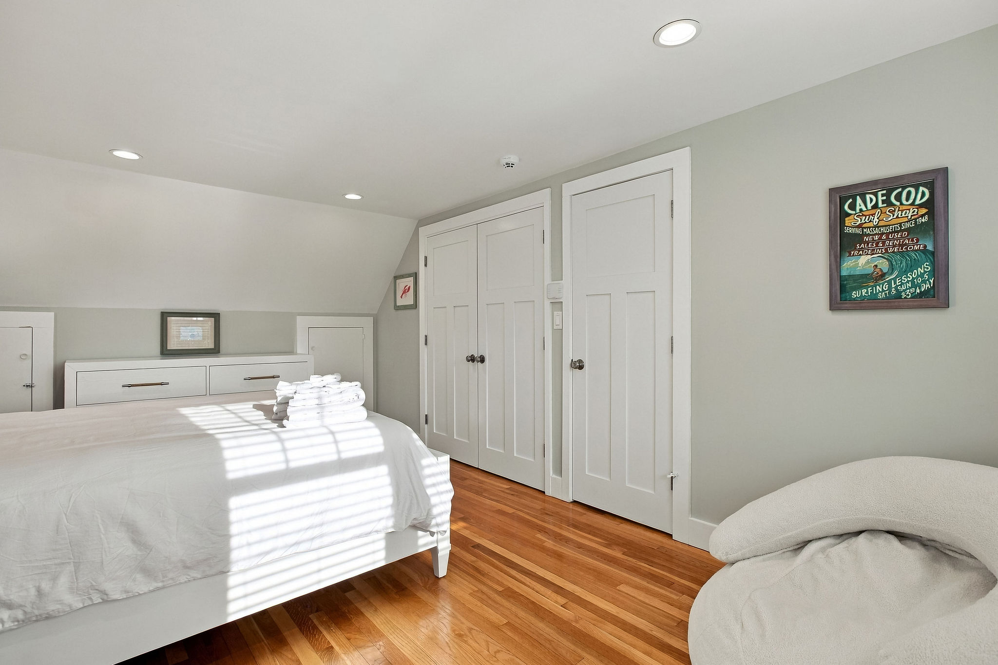Bright coastal bedroom with hardwood floors and generous closet space